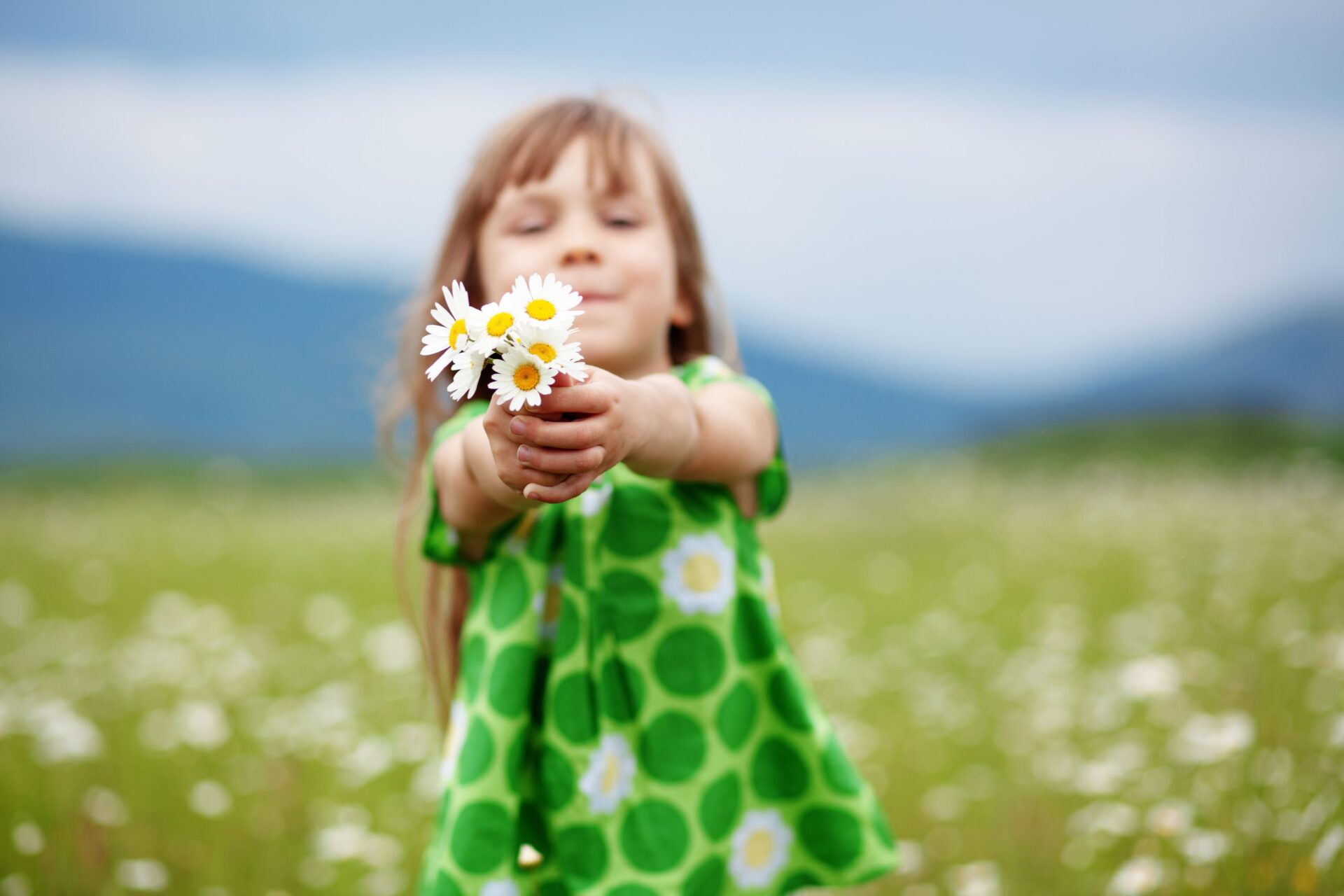 Young girl holding daisies